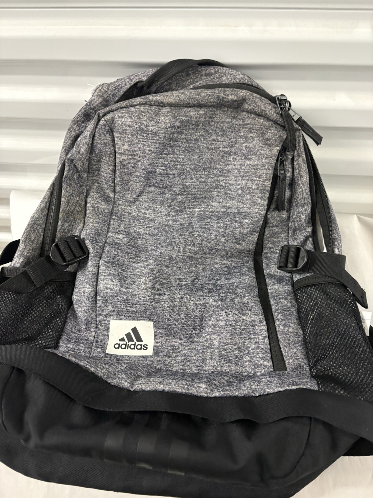 Adidas Defender backpack in grey heather material with black accents.