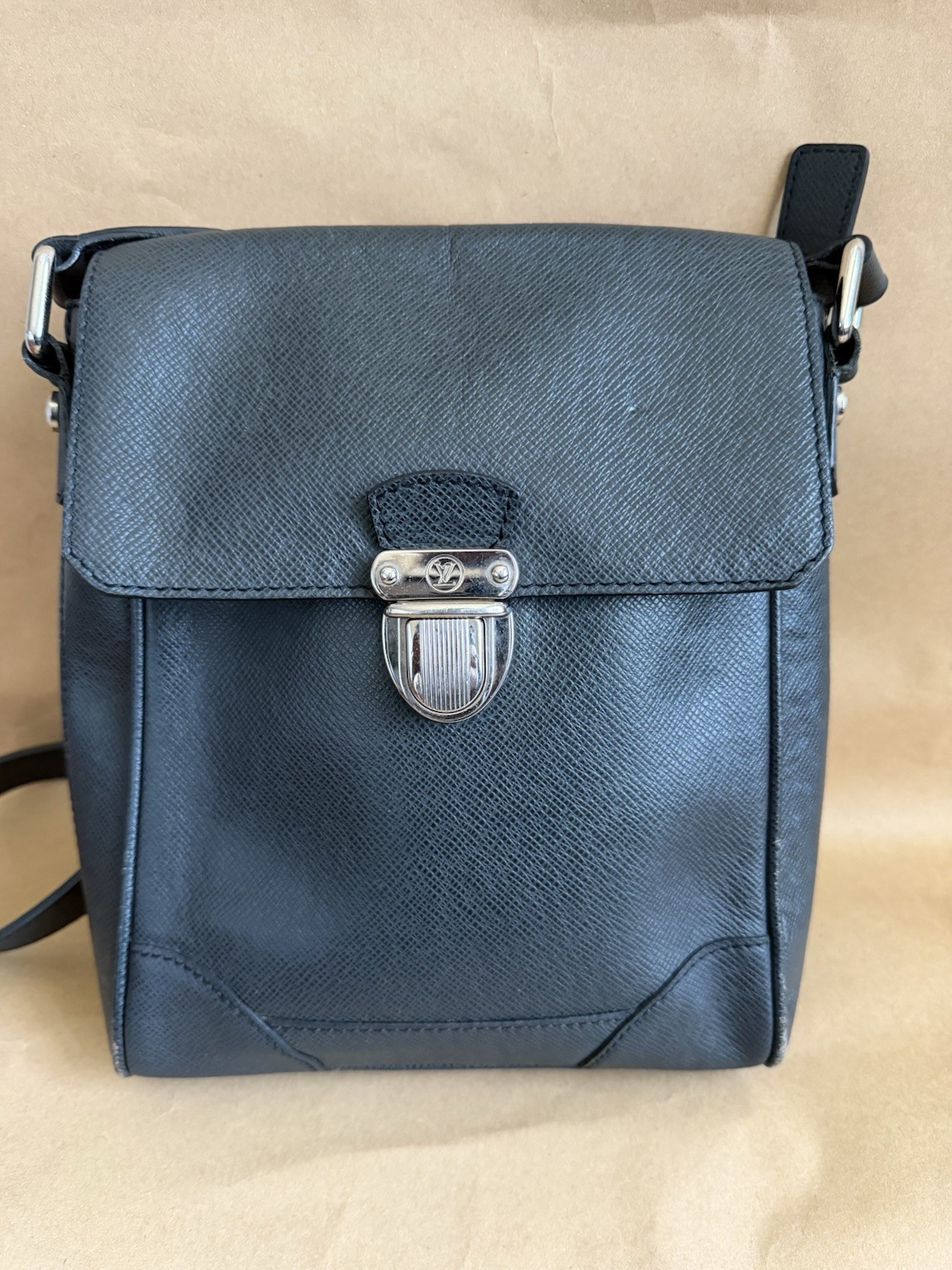 The Louis Vuitton Taiga Luka Shoulder Bag Clasp Logo Adjustable Strap Black