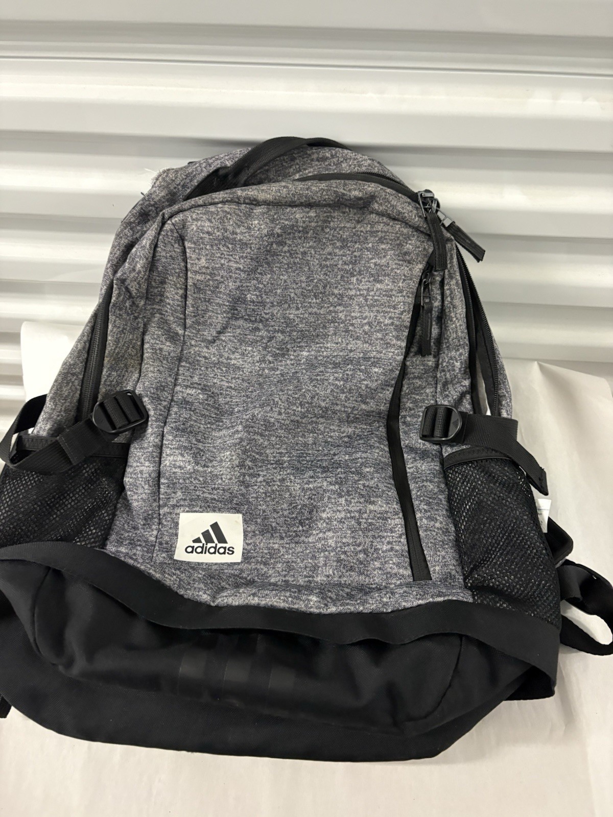 Adidas Defender backpack in grey heather material with black accents.