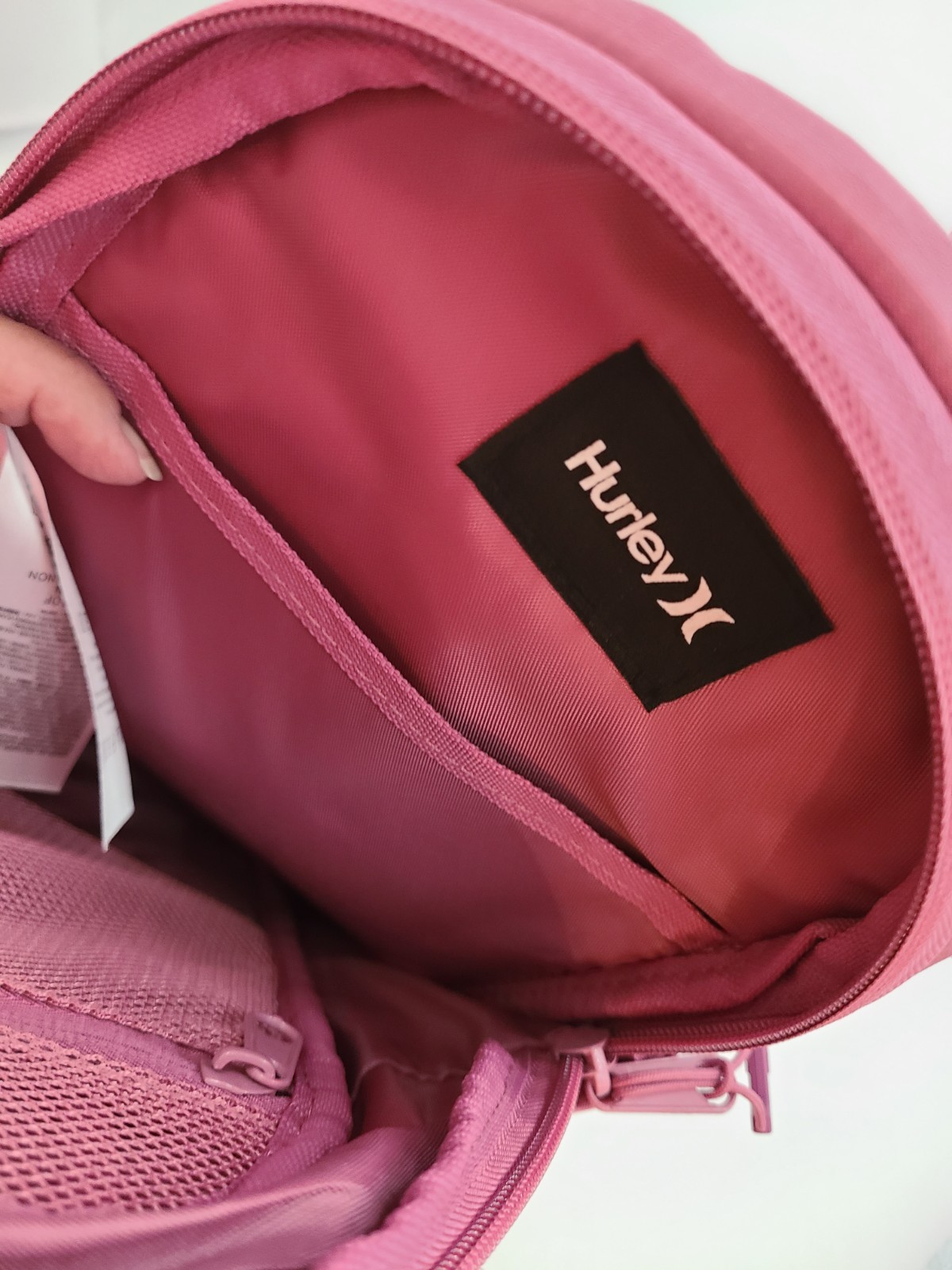 Hurley Terrain Sling Bag Pink features Elastic Bungee Cord System front storage.