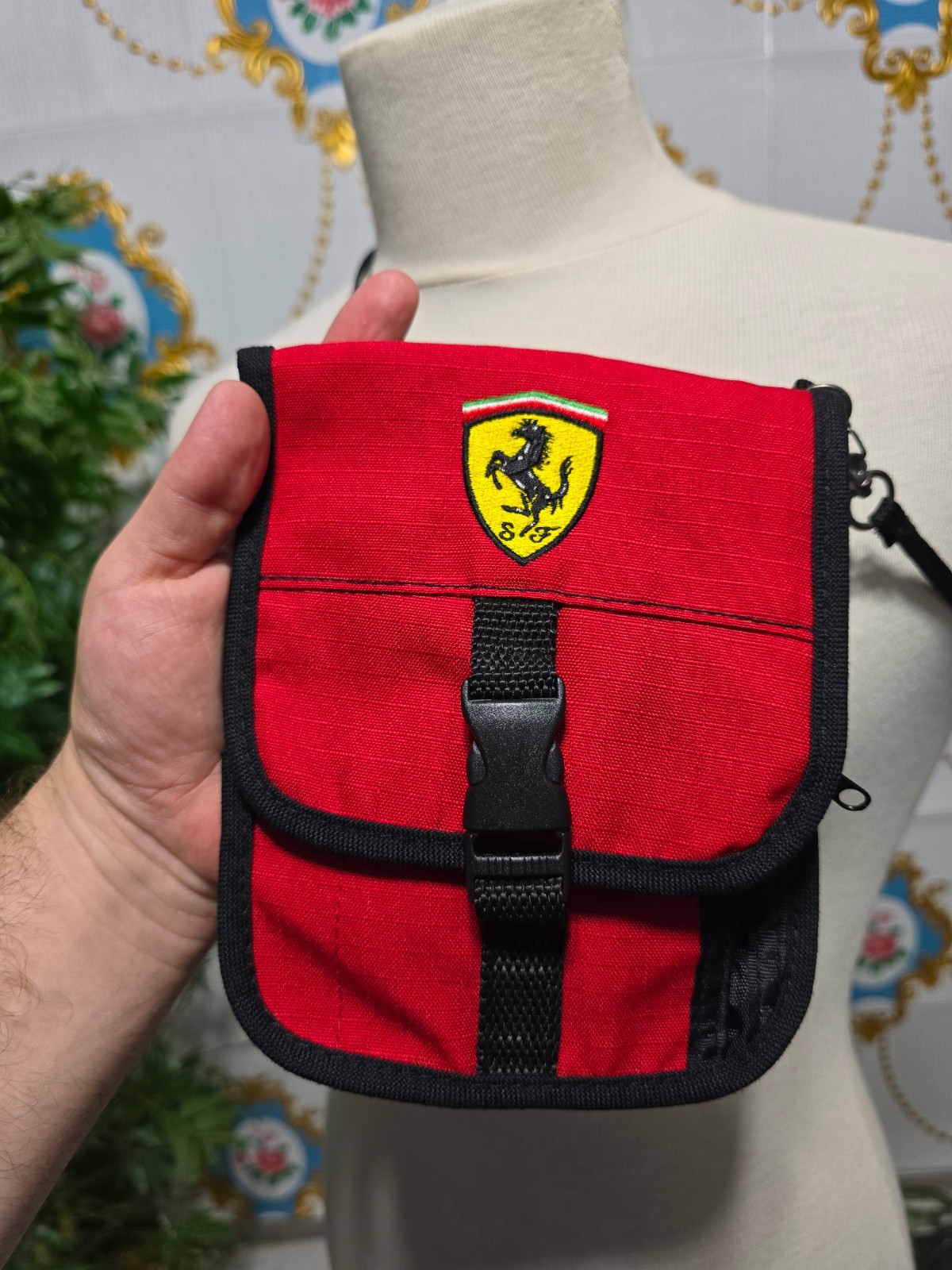 Ferrari branded neck pouch is a red and black canvas bag featuring SCUDERIA LOGO