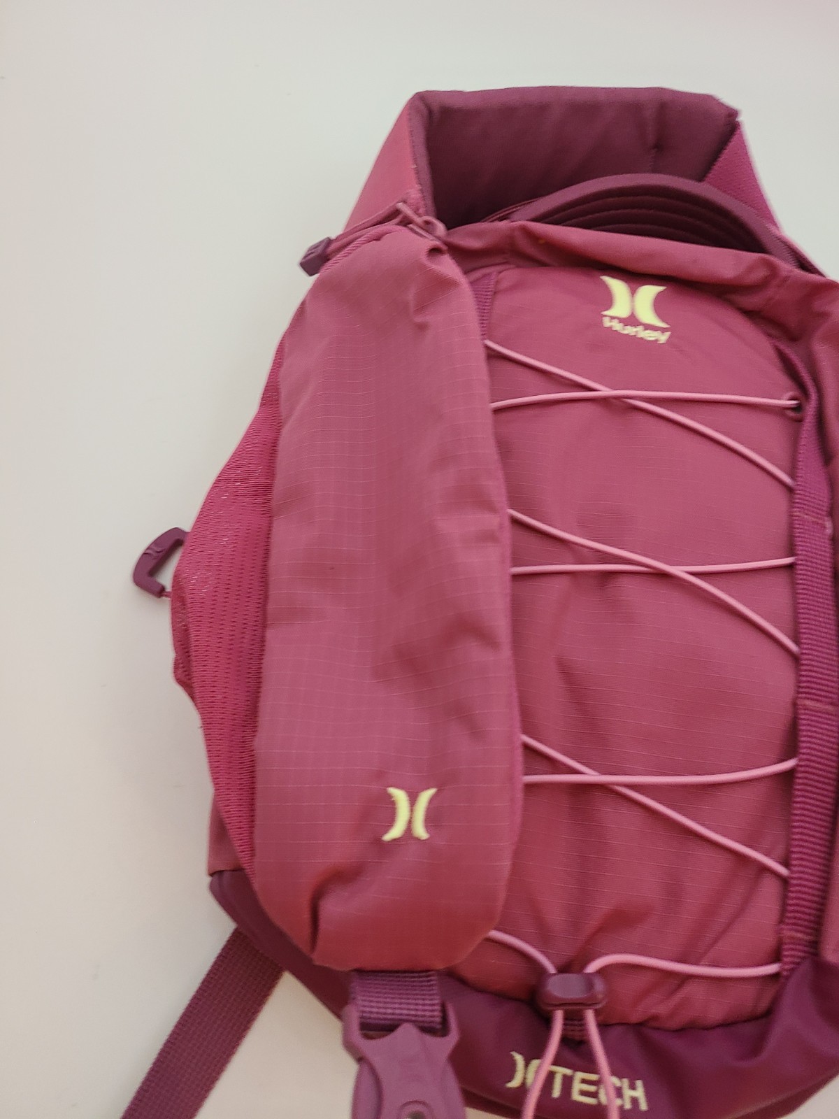 Hurley Terrain Sling Bag Pink features Elastic Bungee Cord System front storage.