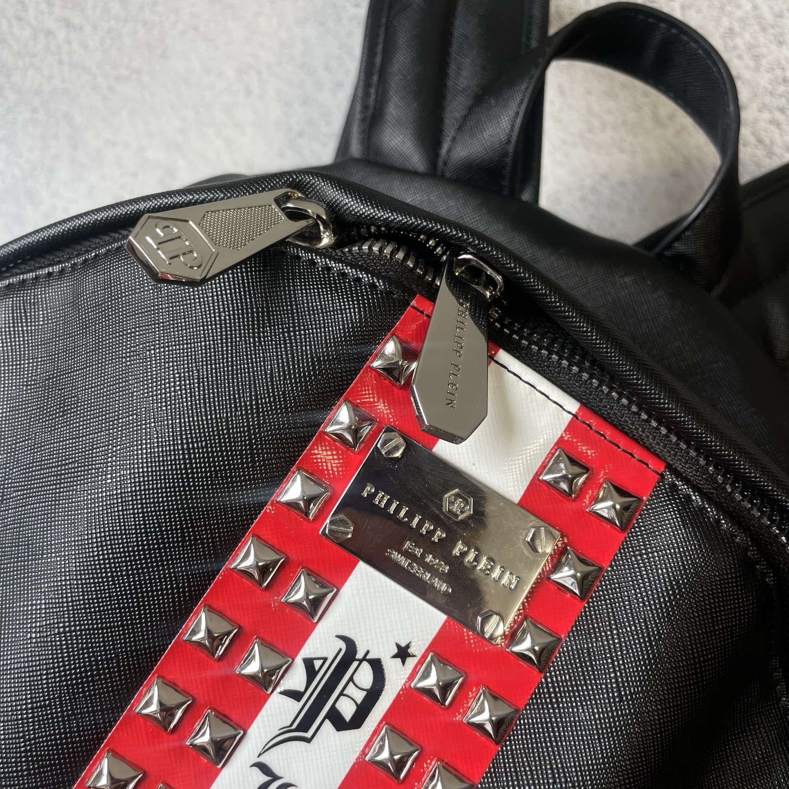 Philipp Plein black backpack, spikes, red center stripe, luxury streetwear SS26.