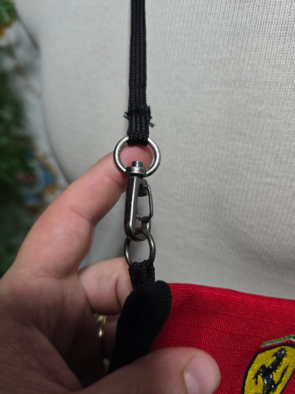 Ferrari branded neck pouch is a red and black canvas bag featuring SCUDERIA LOGO