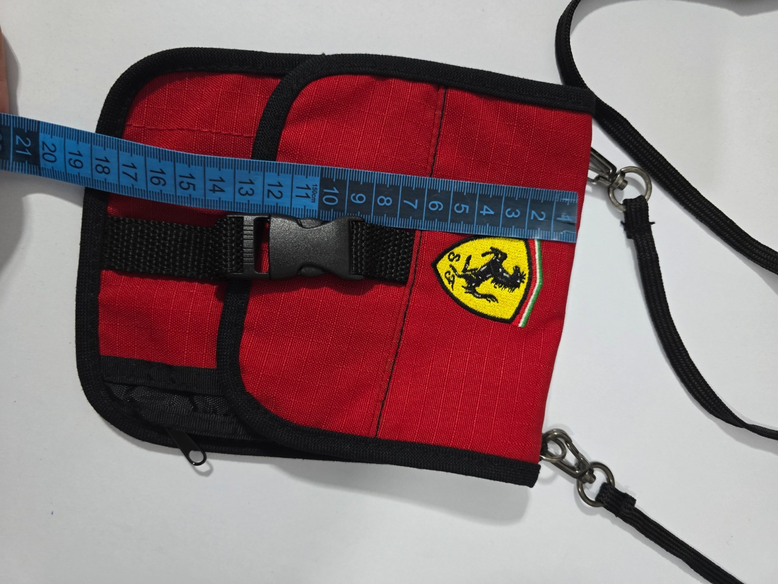 Ferrari branded neck pouch is a red and black canvas bag featuring SCUDERIA LOGO