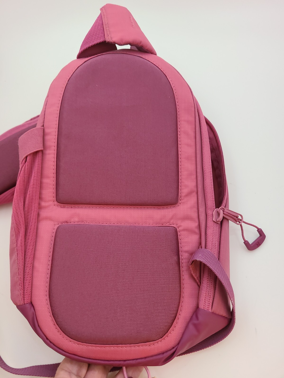Hurley Terrain Sling Bag Pink features Elastic Bungee Cord System front storage.