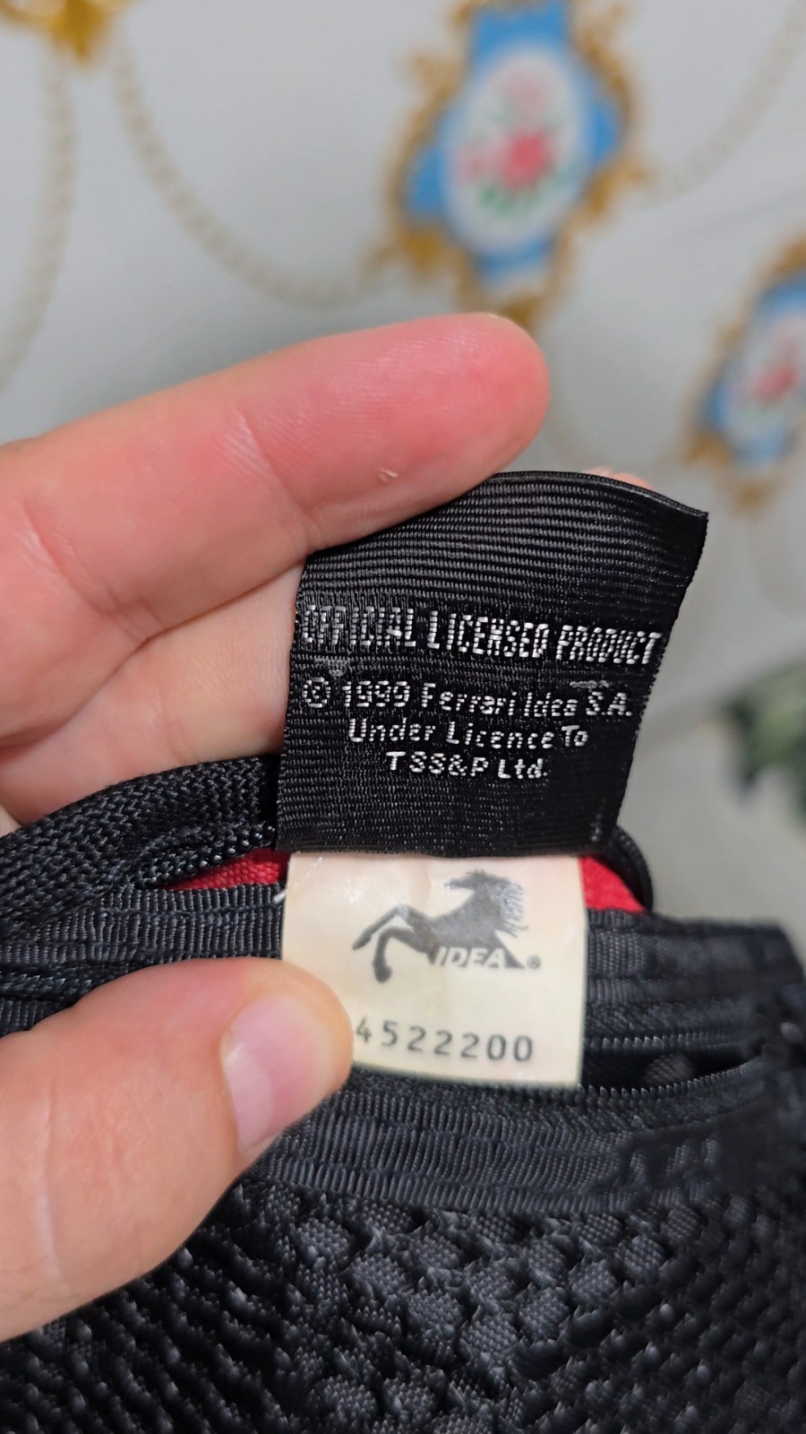 Ferrari branded neck pouch is a red and black canvas bag featuring SCUDERIA LOGO