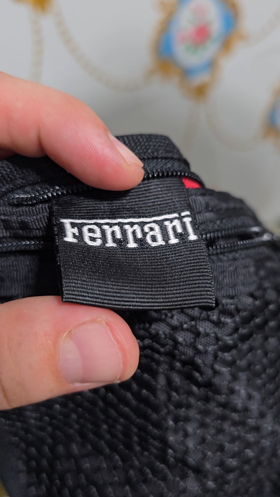 Ferrari branded neck pouch is a red and black canvas bag featuring SCUDERIA LOGO